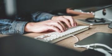 A woman types on her computer.